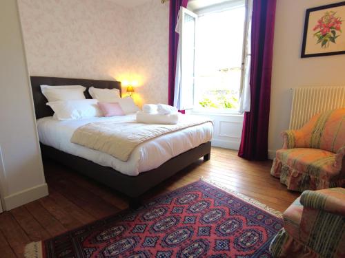 沙托鲁Maison d'hôtes de charme - Au Lys Blanc的一间卧室设有床、窗户和地毯。