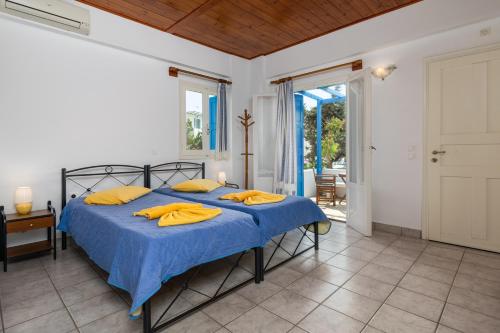 阿波罗尼亚阿波罗客房酒店的一间卧室配有一张带蓝色床单和黄色枕头的床。