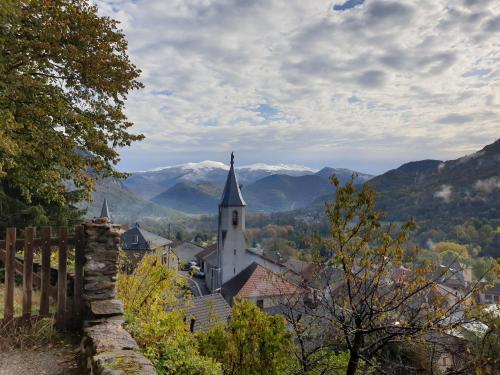 ArignacLe Chalet de Pyrène et Hercule的一座小镇,后面有教堂和山脉