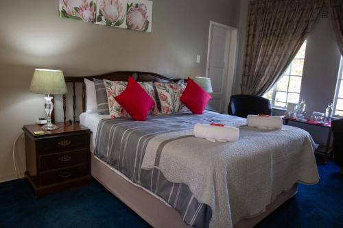 伯诺尼Ailani Blue Room的一间卧室配有一张带红色枕头的大床