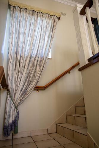 伯诺尼Ailani Blue Room的一个带窗户和窗帘的楼梯