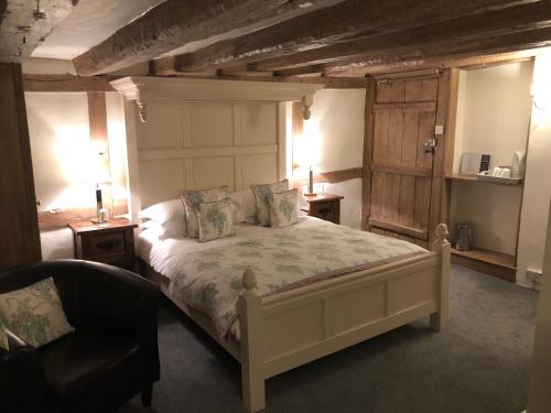 Slinfold罗登华尔酒店的一间卧室配有一张大床、两张桌子和一把椅子