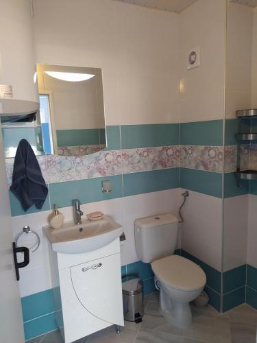 希典Апартамент Blue apartment, гр. Китен的一间带卫生间、水槽和镜子的浴室
