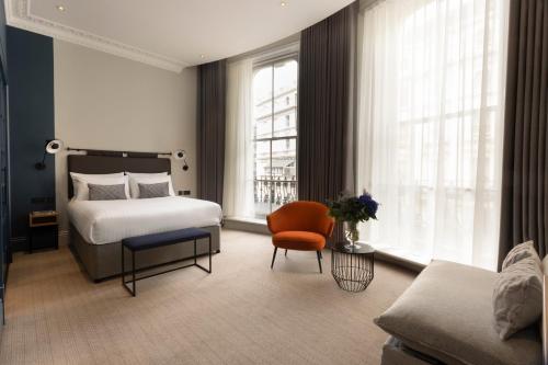 伦敦55 by Le Mirage的一间卧室配有一张床、一把椅子和一张沙发