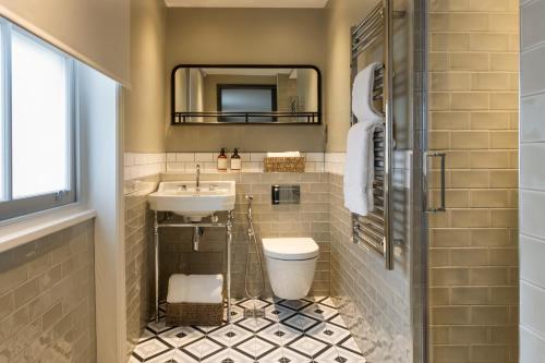 伦敦55 by Le Mirage的一间带水槽、卫生间和镜子的浴室