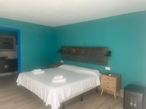 扎霍拉Habitaciones Sajorami Beach的蓝色卧室,配有带2条毛巾的床
