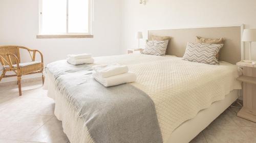 维拉摩拉Villa Aldeia do Golf - BY BEDZY的一间卧室配有一张大床和毛巾
