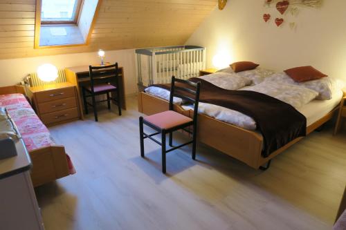 TramelanL'Union B&B - Chambres d'hôtes的一间卧室配有一张床和一张带两把椅子的桌子