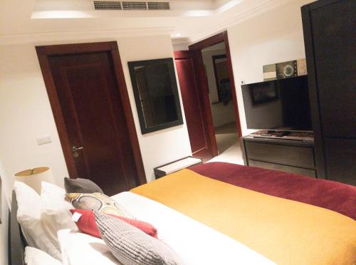多哈Luxury 2 bedroom Apt in The Pearl with Marina view的酒店客房,配有床和电视