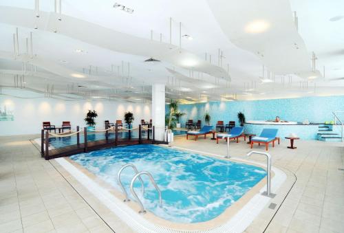 卡萨布兰卡肯梓塔酒店的大房间设有一个大型游泳池,配有桌椅