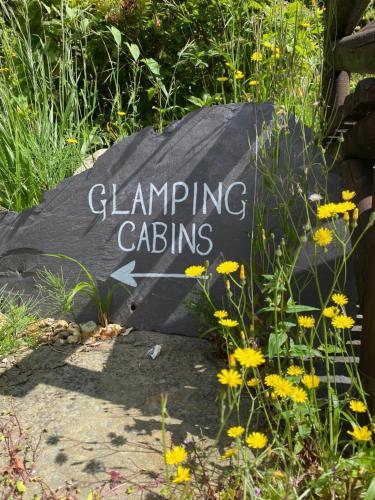 纽卡斯尔Enniskeen Estate & Forest Spa - Boutique Riverside Glamping Cabins的黄色花卉园艺园的标志