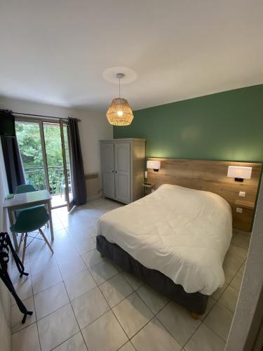 梅吕埃江特德拉酒店的一间卧室配有一张床、一张桌子和一张桌子