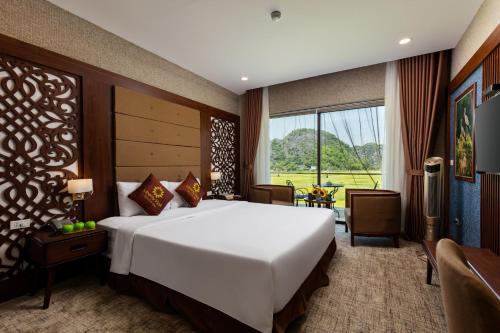 宁平Liberty Hall Tam Coc Hotel & Villa的一间卧室设有一张大床和一个大窗户