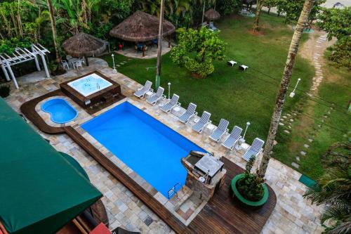 伯迪亚哥Indaiá Praia Hotel的享有带椅子和庭院的游泳池的上方景色