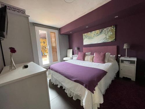阿格特Los Veroles的一间卧室设有紫色的墙壁和一张大床