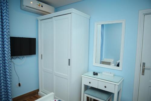 赫尔格达Tiba Rose hurghada的蓝色的客房配有白色橱柜和电视