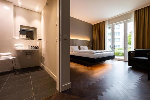 柏林GINN City & Lounge Yorck Berlin的一间卧室设有一张床和一间客厅。