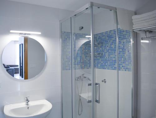 桑亨霍Apartamentos Rozas Vellas的一间带玻璃淋浴和水槽的浴室
