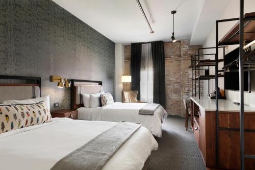 明尼阿波利斯Hewing Hotel的酒店客房配有两张床和一张书桌