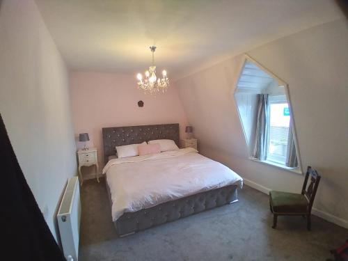 科芙Sea View Cottage, 2 bedrooms with stunning views的一间卧室配有一张带吊灯和窗户的床。