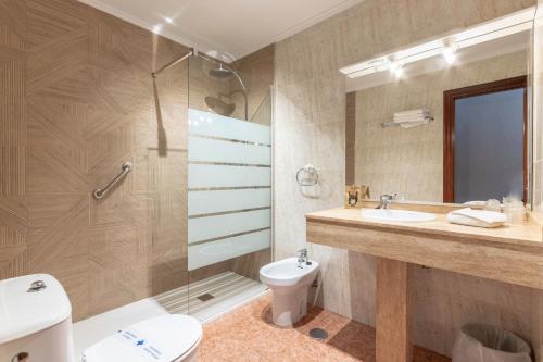 诺哈节日酒店的浴室配有卫生间、盥洗盆和淋浴。