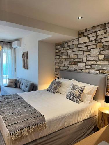 莫雷逊Peri Elxis Luxury Suites的一间卧室设有一张带石墙的大床