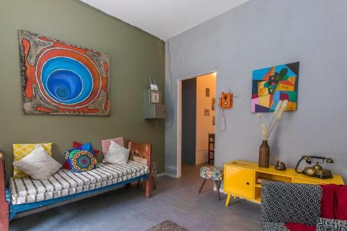 圣保罗Hospedaria da Mama的客厅配有沙发和墙上的绘画
