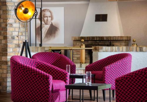 布雷纳乡村公园酒店的配有粉红色椅子和桌子的房间