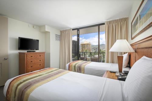 檀香山雅诗顿威基基日落酒店的酒店客房设有两张床和大窗户。
