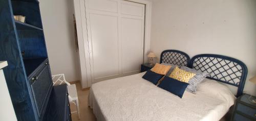 萨阿拉德洛斯阿图内斯Ático Bahía de la Plata的小卧室配有蓝色和黄色枕头