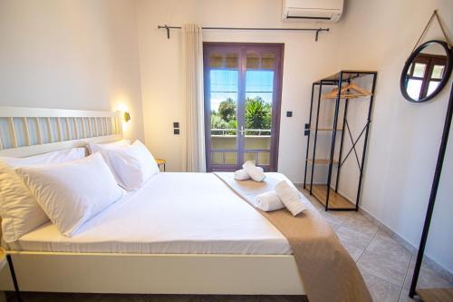 普雷韦扎Palmeira Sea & City的卧室配有一张大白色床和窗户