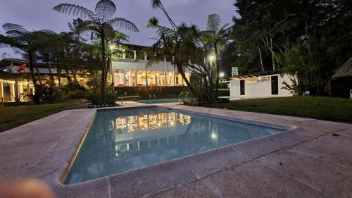 科万Posada Montaña del Quetzal的夜间在房子前面的游泳池