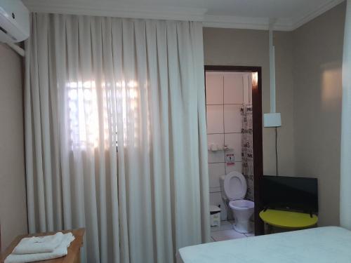 São Gonçalo do AmaranteCasa do Mochileiro Airport Hostel的一间卧室设有一张床、一个卫生间和一个窗口