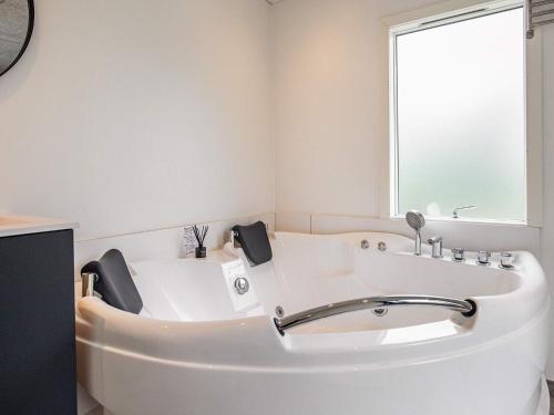 奥特鲁普Holiday home Otterup XXXI的带窗户的浴室内的白色浴缸