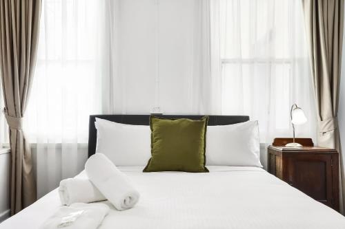 温特沃斯瀑布君怡酒店的一张带白色床单和绿色枕头的床