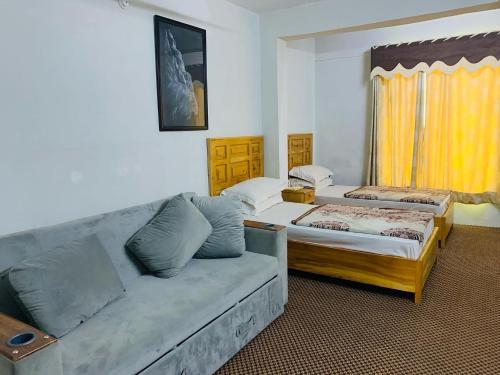 吉尔吉特Naveed Tourist Inn的客厅配有沙发和1张床