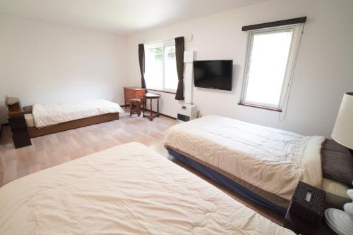 小樽桔恭(KIKYO)的一间卧室配有两张床和一台平面电视