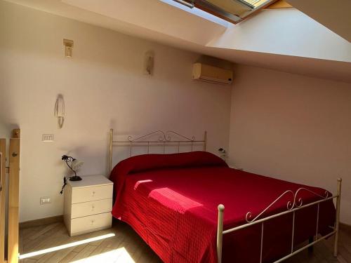 阿其利亚Country Love Dragona House tra mare e città的一间卧室配有一张带红色毯子的床