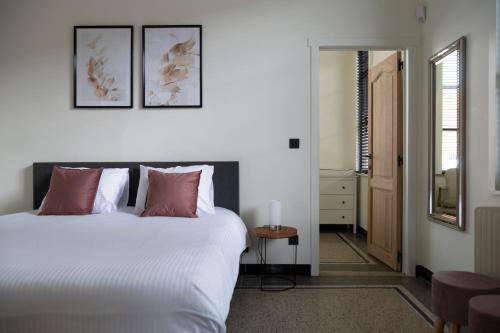 Lo-ReningeVakantievilla Leonie的卧室配有带粉红色枕头的大型白色床