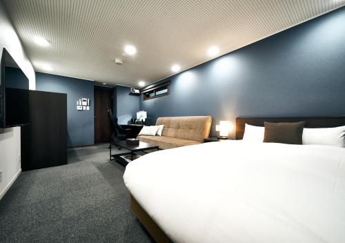京都Villa Front Kyoto Seimei的酒店客房设有一张大床和一张沙发。