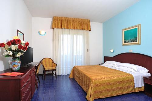 里乔内Hotel Vittoria的配有一张床和花瓶的酒店客房