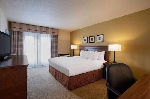 里贾纳Travelodge Suites by Wyndham Regina - Eastgate Bay的酒店客房,配有床和电视