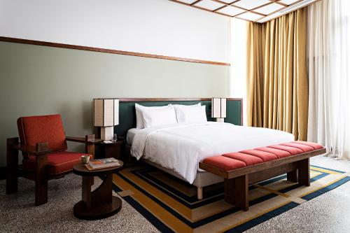 阿比让La Maison Palmier Abidjan, a Member of Design Hotels的配有一张床和一把椅子的酒店客房