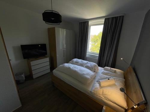 杜塞尔多夫Hotel Sonnenschein nähe Messe und Flughafen的一间卧室设有一张床、一台电视和一个窗口。