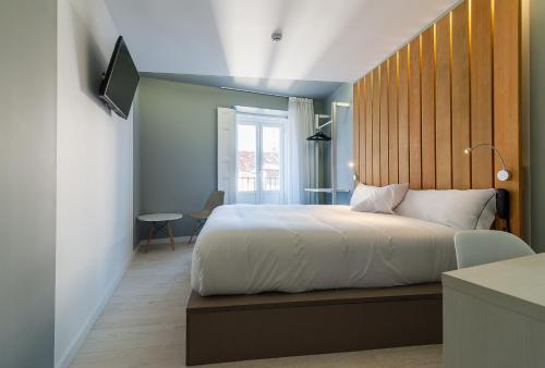 马德里B&B HOTEL Madrid Centro Fuencarral 52的一间卧室配有一张大床和木制床头板