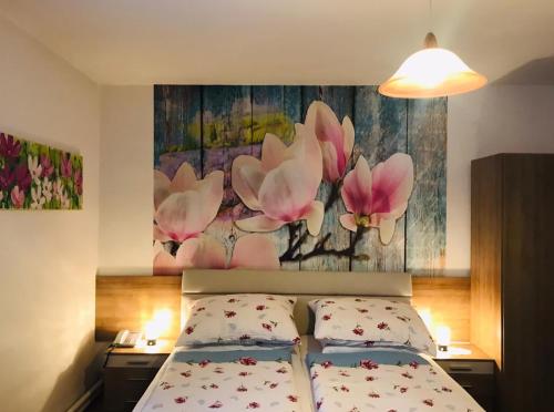 BrauneggBraunegger-Hof Waldviertel的卧室配有一张床,墙上挂有绘画作品