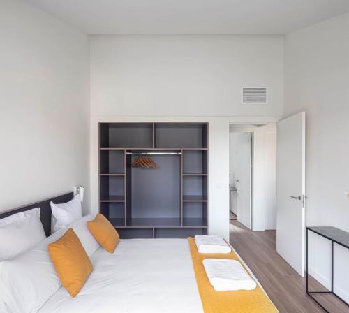 洛格罗尼奥Invino Apartments的卧室配有带橙色枕头的大型白色床