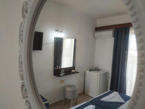 阿彻奇洛斯纳基索斯酒店的配有床和冰箱的镜子