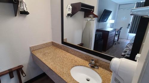 佛罗伦萨Red Roof Inn Florence, SC的一间带水槽和大镜子的浴室