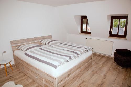 TriebesIn Triebes的白色墙壁和木地板的客房内的一张床位